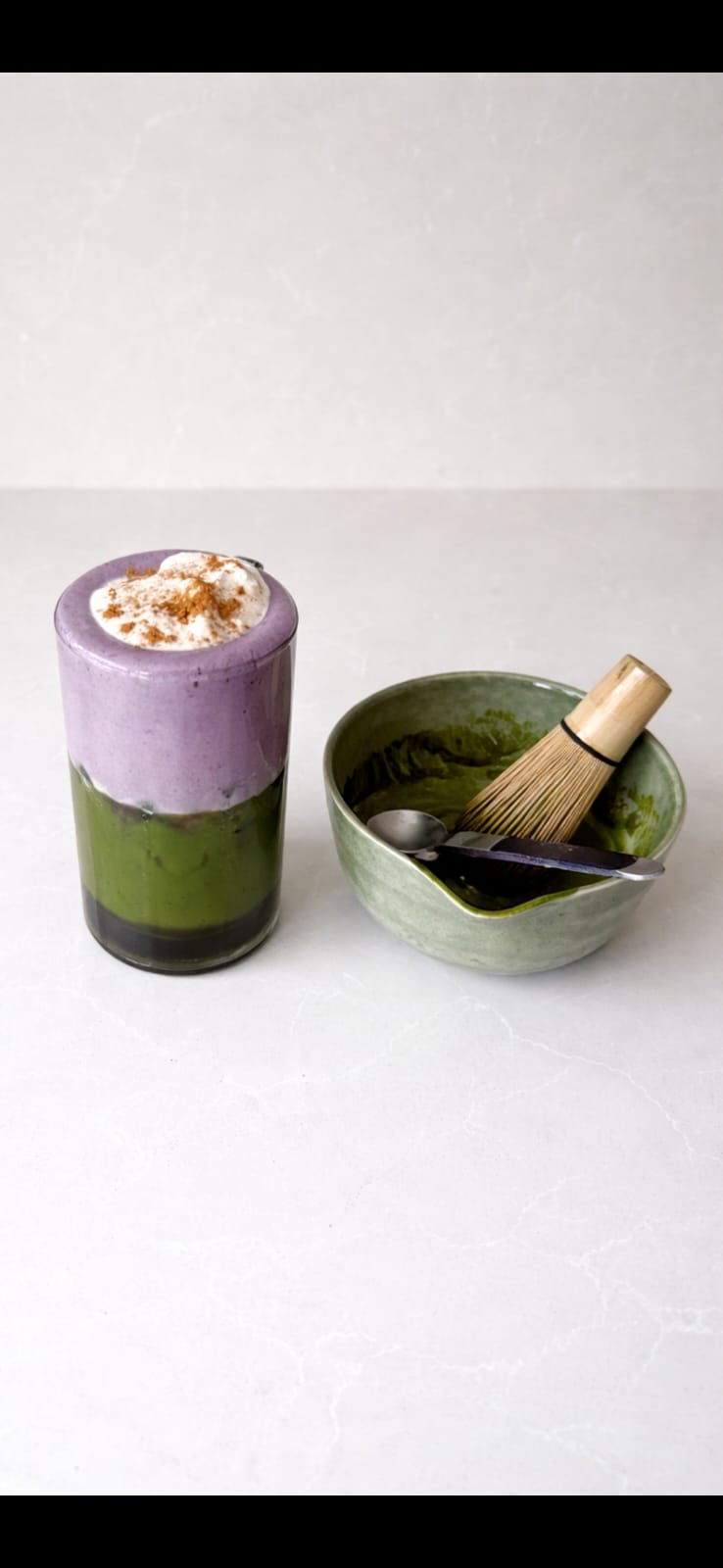 Layered matcha beverage and traditional whisk from Falak Haus